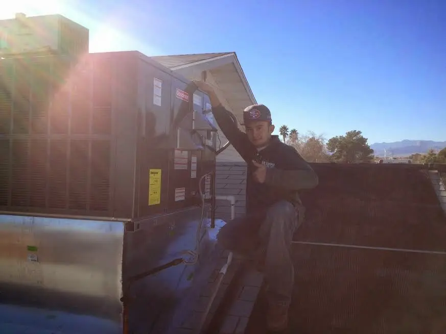 HVAC technician performing Boiler Repair on a rooftop unit in Caddo Mills